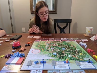 Ma fille essaie de décider quelles cartes acheter dans un jeu de The Red Burnoose